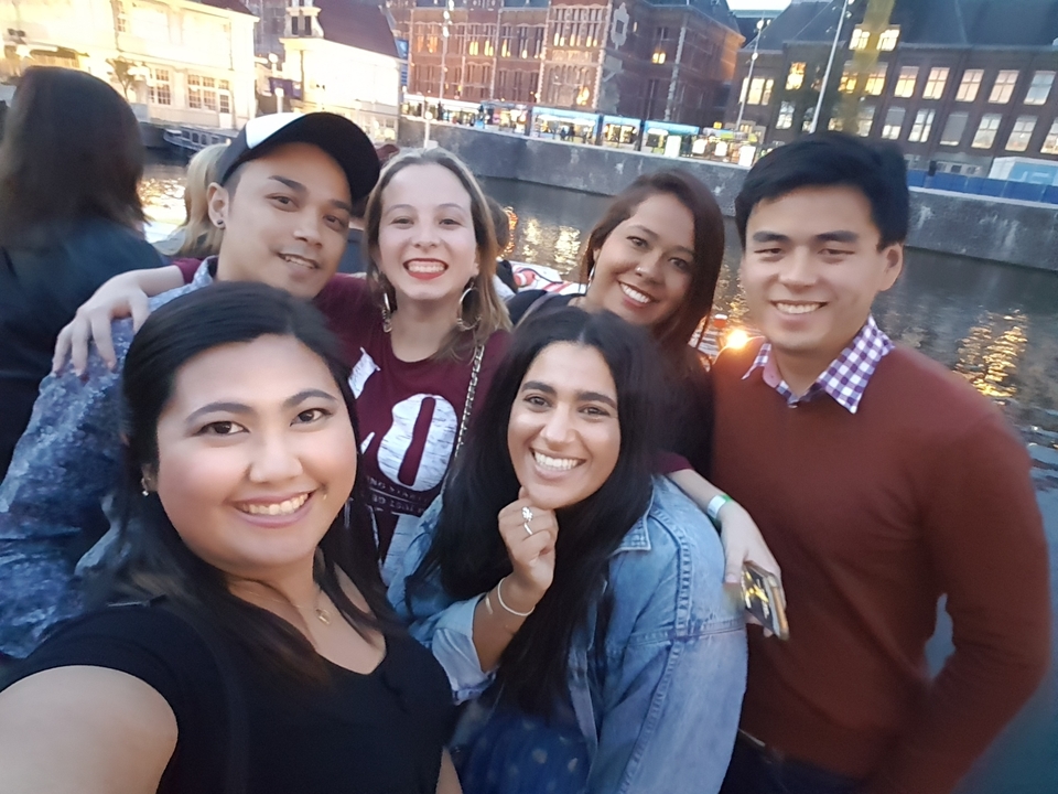 Groupe d'amis posant au bord d'un canal en soirée.