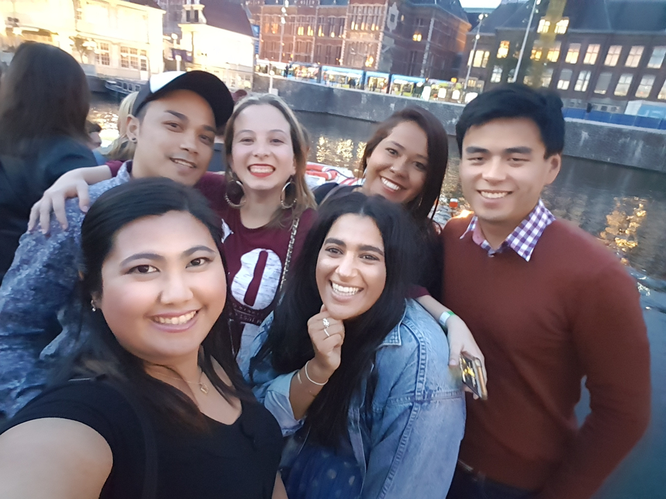 Groupe d'amis posant au bord d'un canal en soirée.