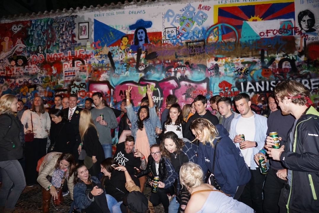 Groupe de personnes posant devant un mur de graffitis.