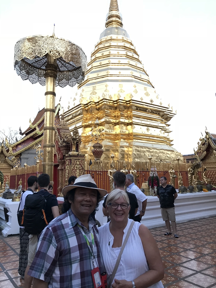 Groupe de personnes visitant un temple doré.