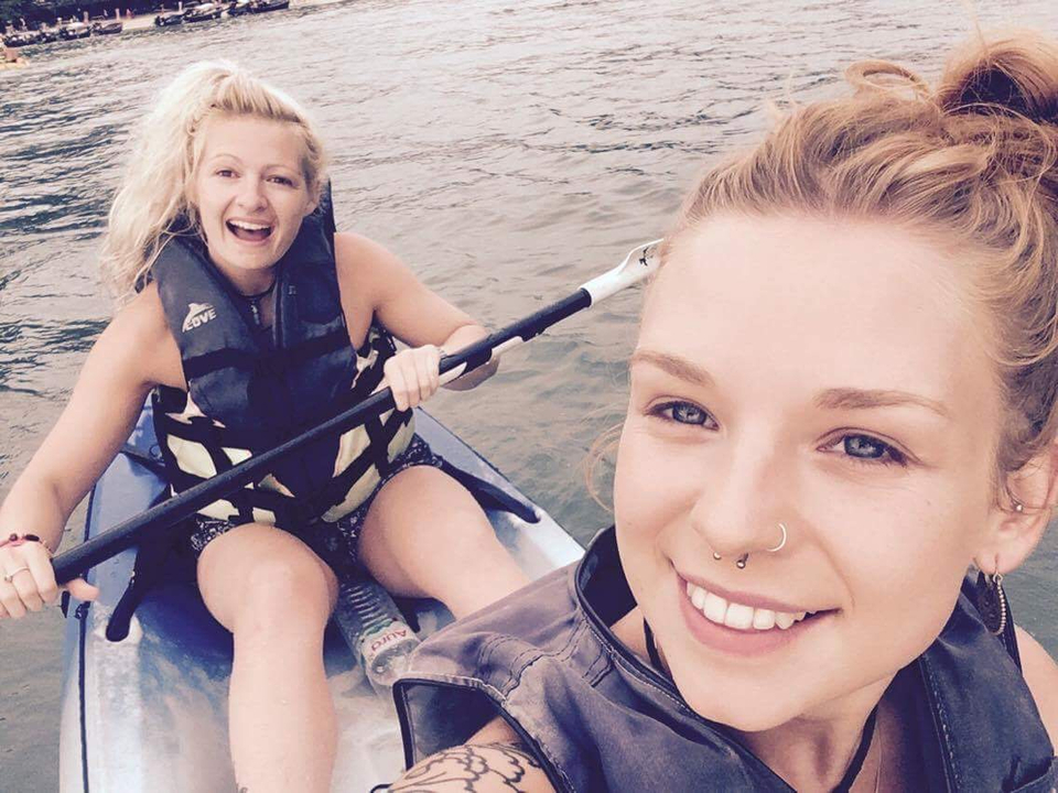 Two women kayaking on a river.