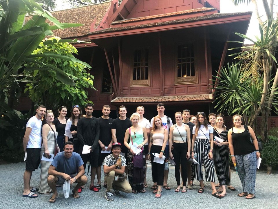 Group of people posing in front of a traditional building.