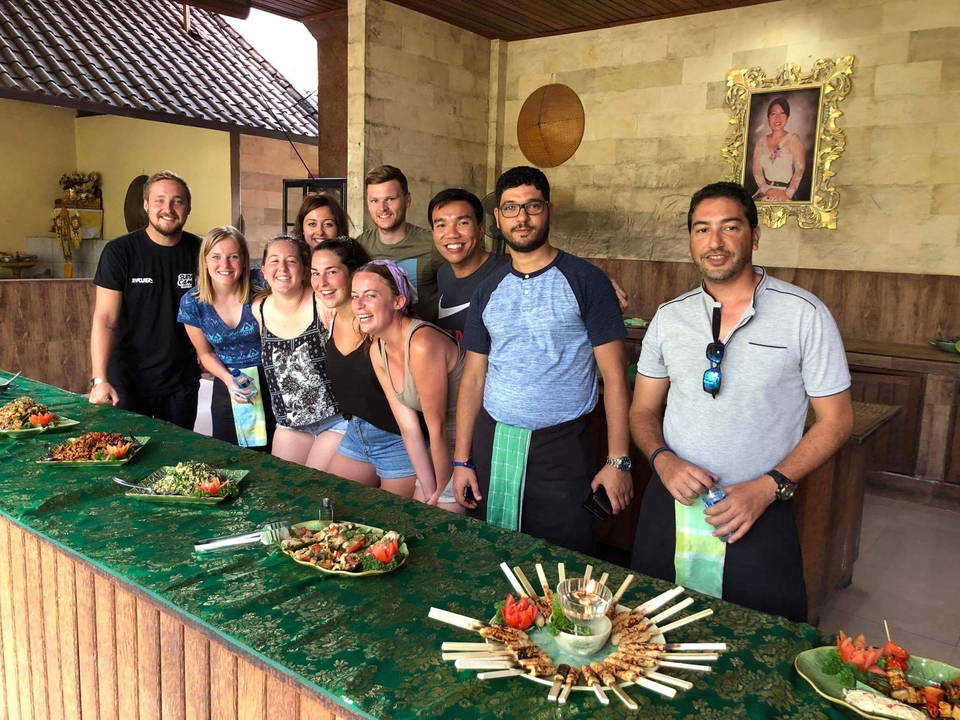 Groupe posant devant des plats culinaires en intérieur.