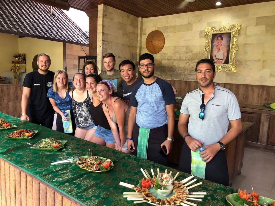 Groupe posant à l'intérieur avec de la nourriture présentée sur une longue table.
