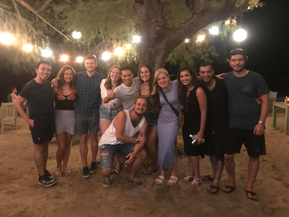 Photo de groupe sous des arbres éclairés la nuit.