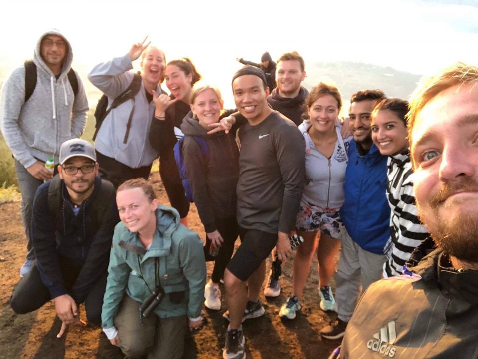 Selfie de groupe avec une vue sur les montagnes en arrière-plan.