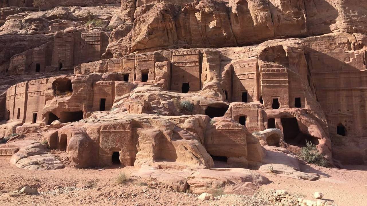 Architecture taillée dans la roche sur une face de montagne à la lumière du jour.