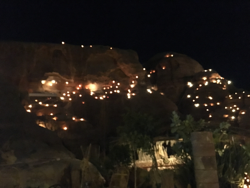 Photo nocturne d'un paysage rocheux avec des lumières.