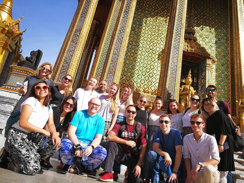 Grand groupe devant un temple orné.
