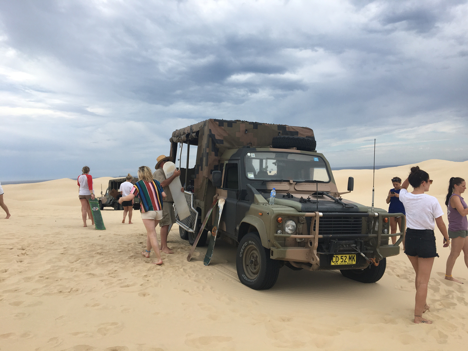 People on a desert tour with an off-road vehicle.