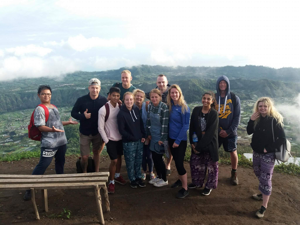 Group of people posing on a hill with a scenic background.