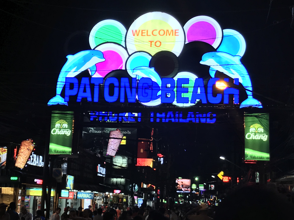 Patong Beach sign lit up at night.