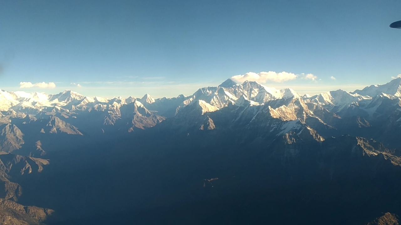 Chaîne de montagnes aux sommets enneigés sous un ciel dégagé.