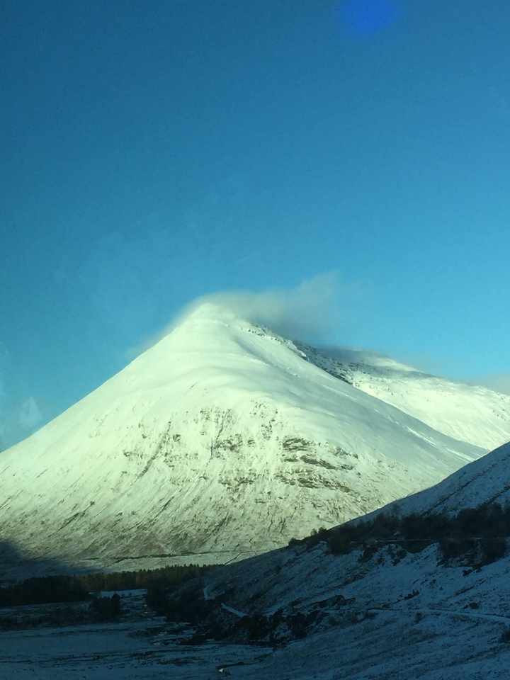 Sommet d'une montagne enneigée dans un ciel bleu clair.