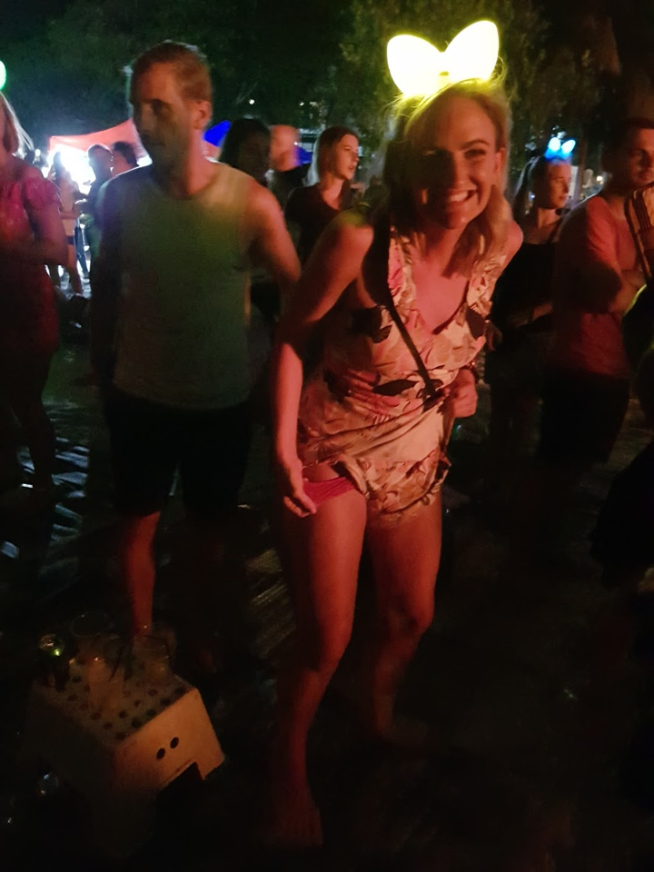 Personne profitant d'une fête la nuit avec des gens autour d'elle.