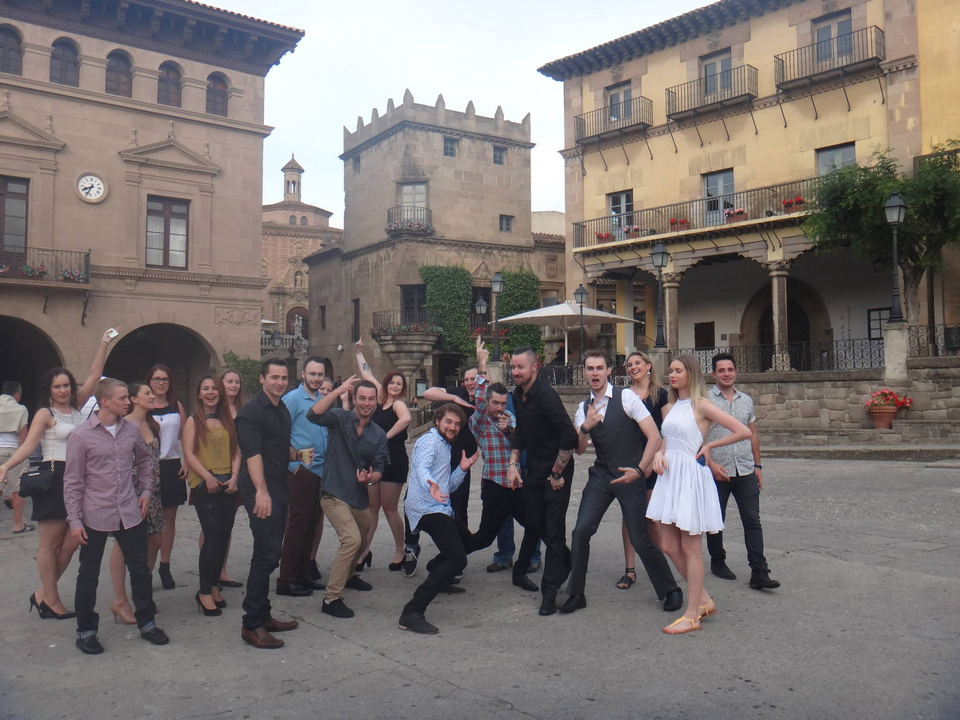 Groupe de personnes posant de manière ludique sur une place historique.