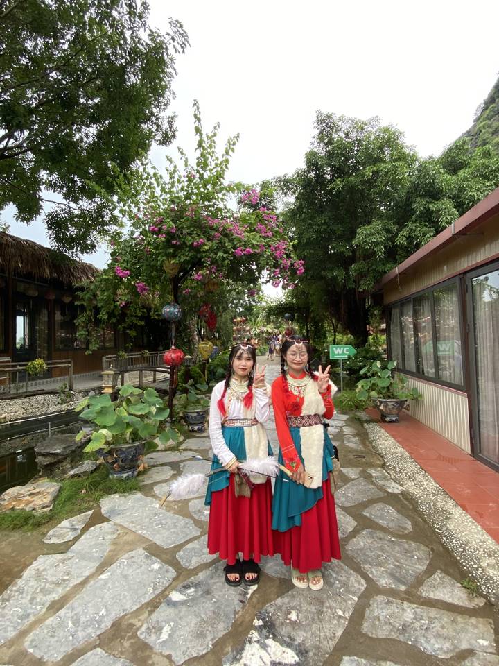 Des femmes en robes traditionnelles posent pour une photo.
