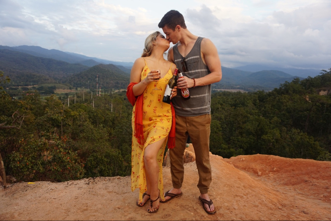 Couple s'embrassant dans un paysage de montagne.