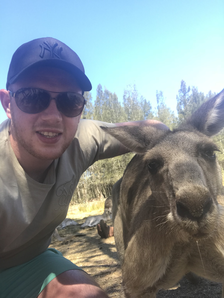 Man taking a selfie with a kangaroo.
