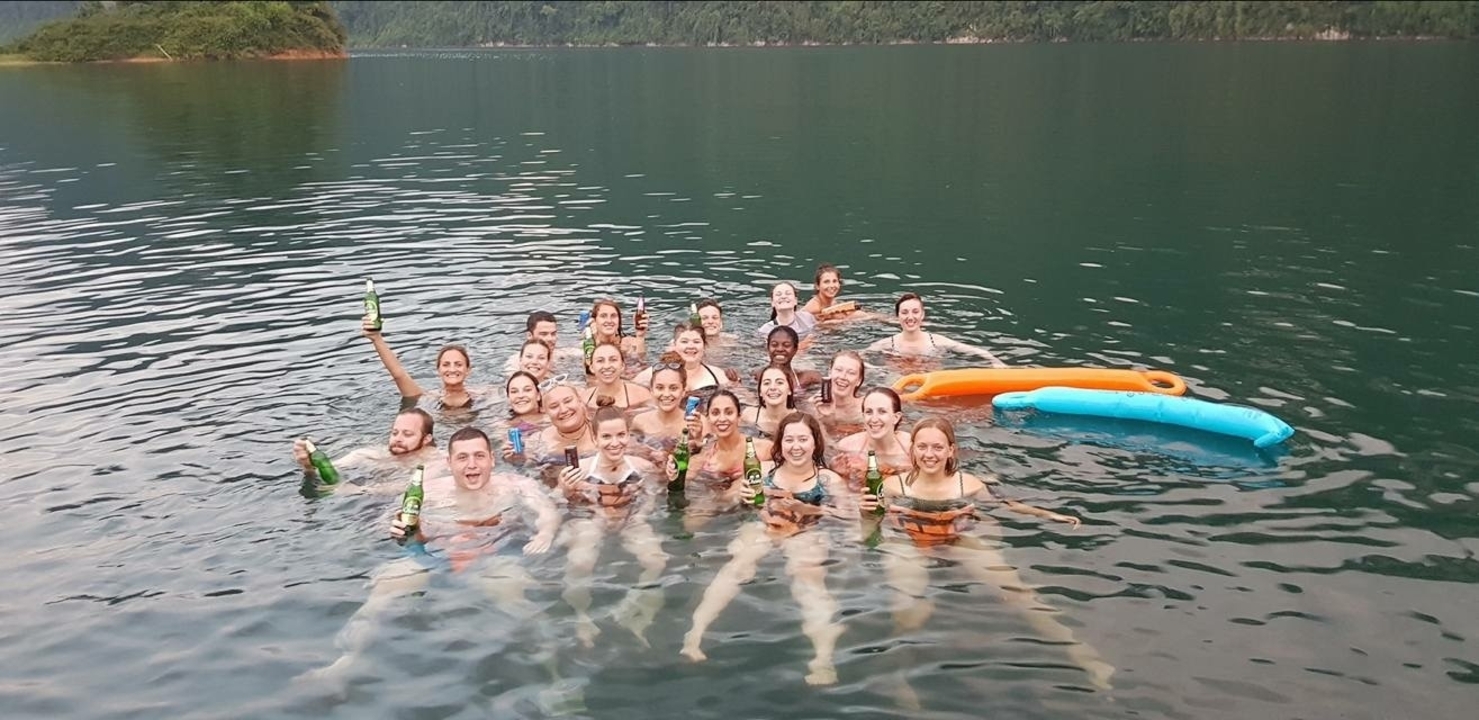 Groupe de personnes se baignant dans un lac avec des boissons.
