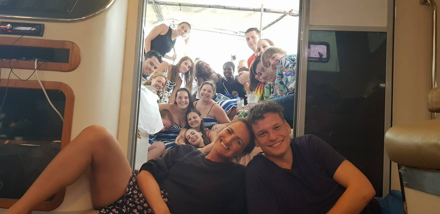 Groupe de personnes posant avec enthousiasme à l'intérieur d'un bateau.