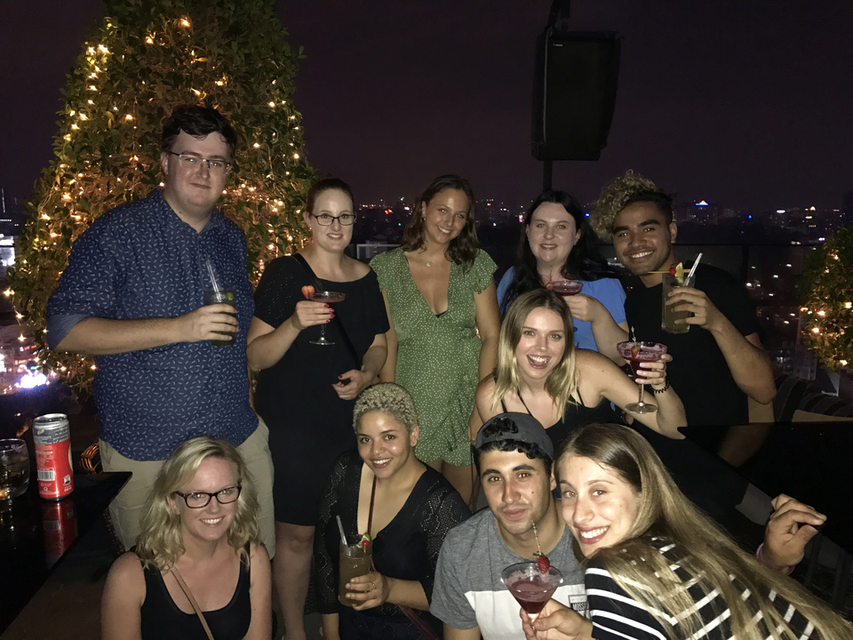 Groupe dégustant des boissons dans un bar sur le toit, la nuit.