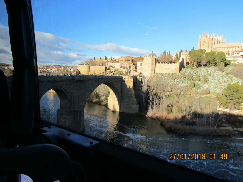 Vue d'un pont historique en pierre depuis la fenêtre d'un bus.