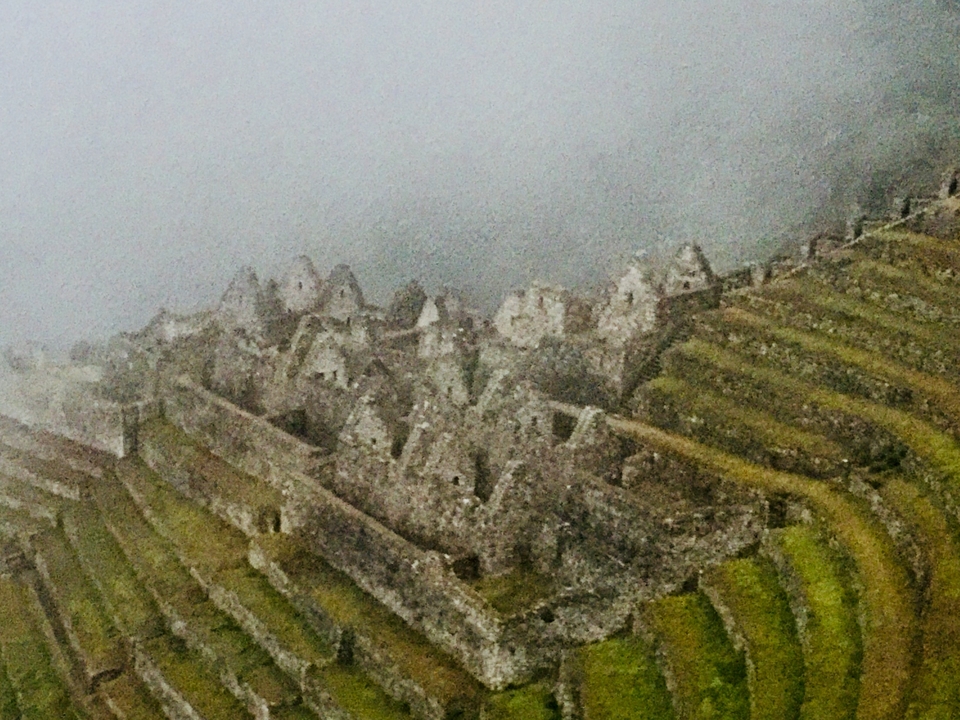 Ruines du Machu Picchu partiellement obscurcies par le brouillard.