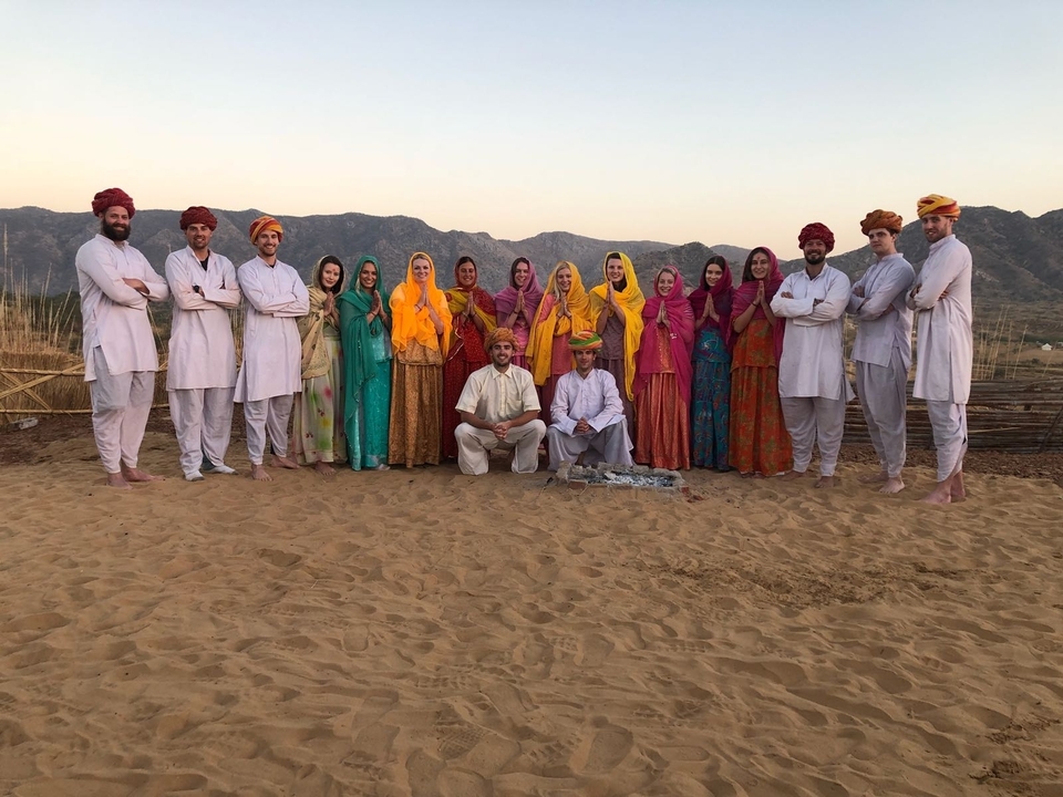 Grand groupe en tenue traditionnelle posant à l'extérieur.