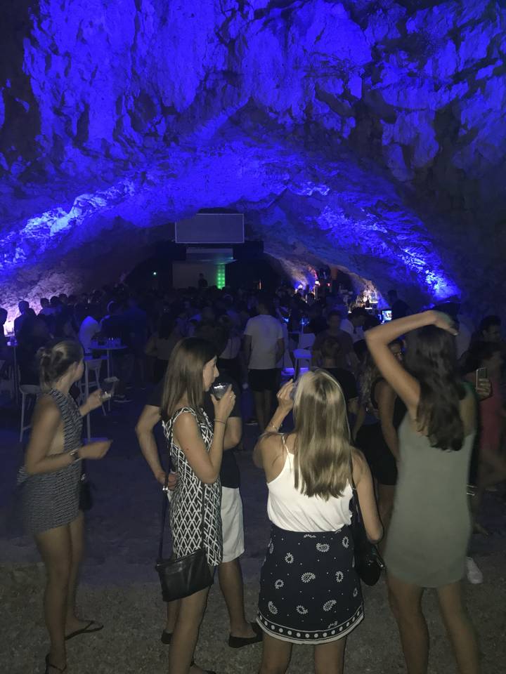 Personnes dansant dans une grotte vivement éclairée