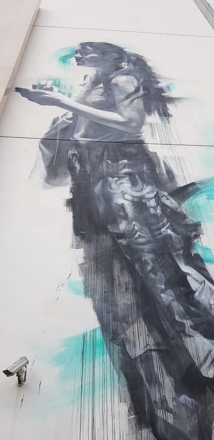 Peinture murale artistique représentant une figure abstraite noire et bleue.