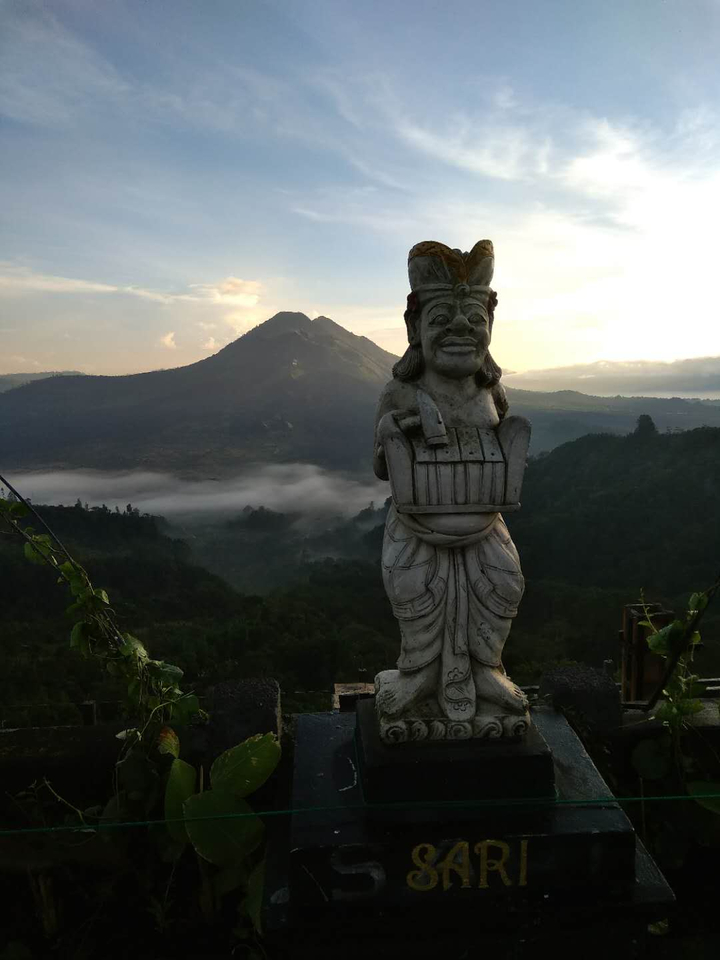 Statue with mountains in the background at sunset.