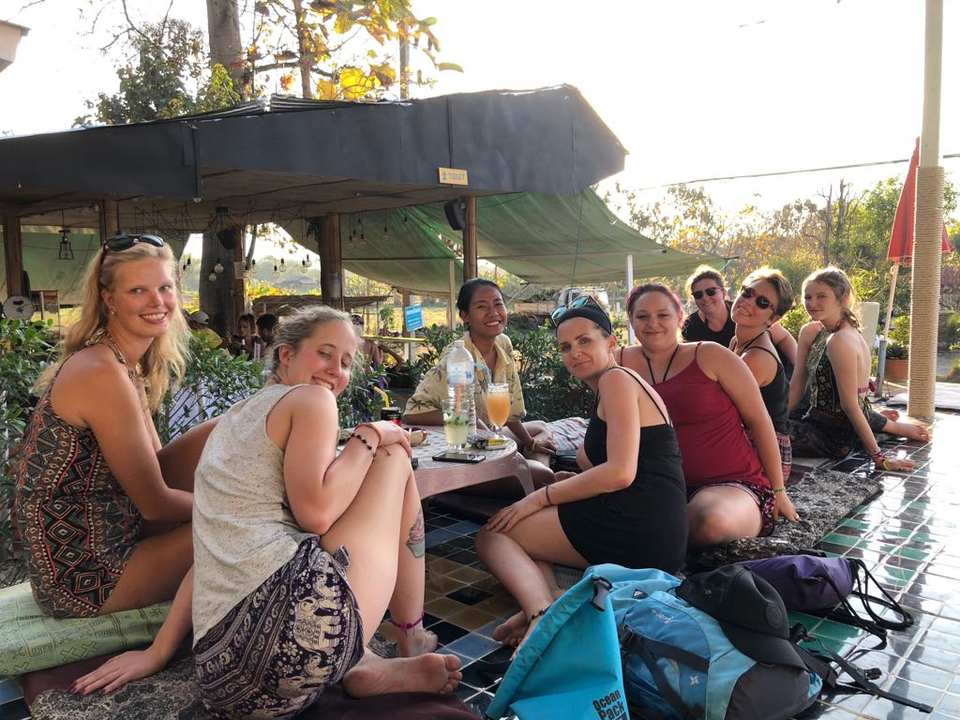 Group of people seated and enjoying drinks at a patio.