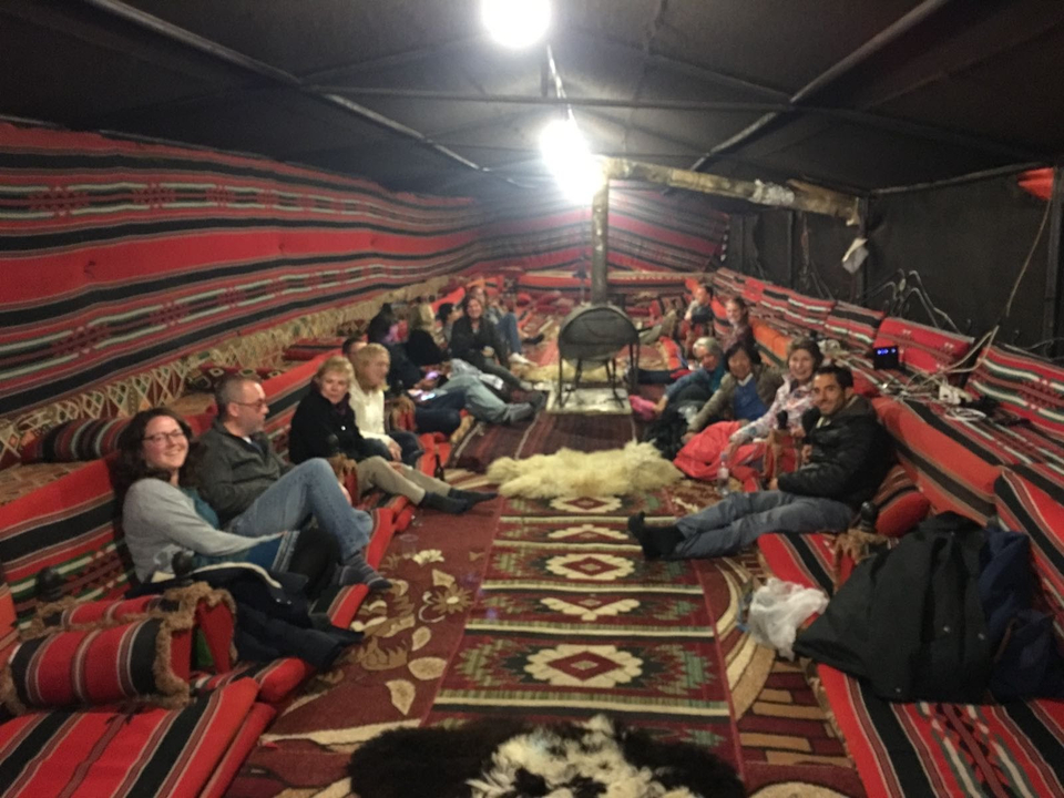 Groupe de personnes dans une tente bédouine traditionnelle.