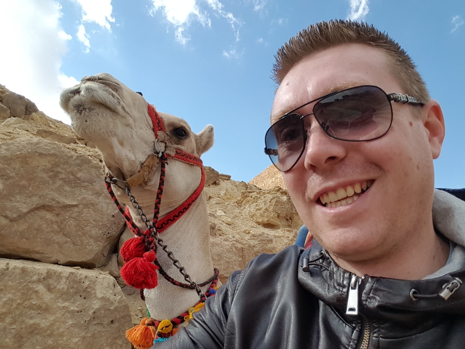 Homme prenant un selfie avec un chameau.