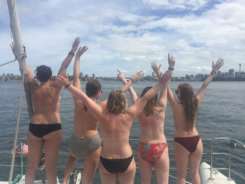 Group of people on a boat with a city skyline view.