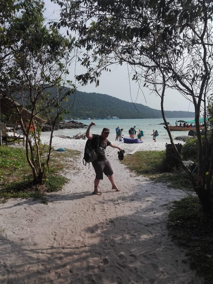 Person posing excitedly on a beach path.