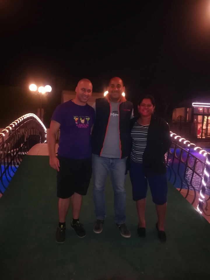 Trois personnes posant sur un pont la nuit.