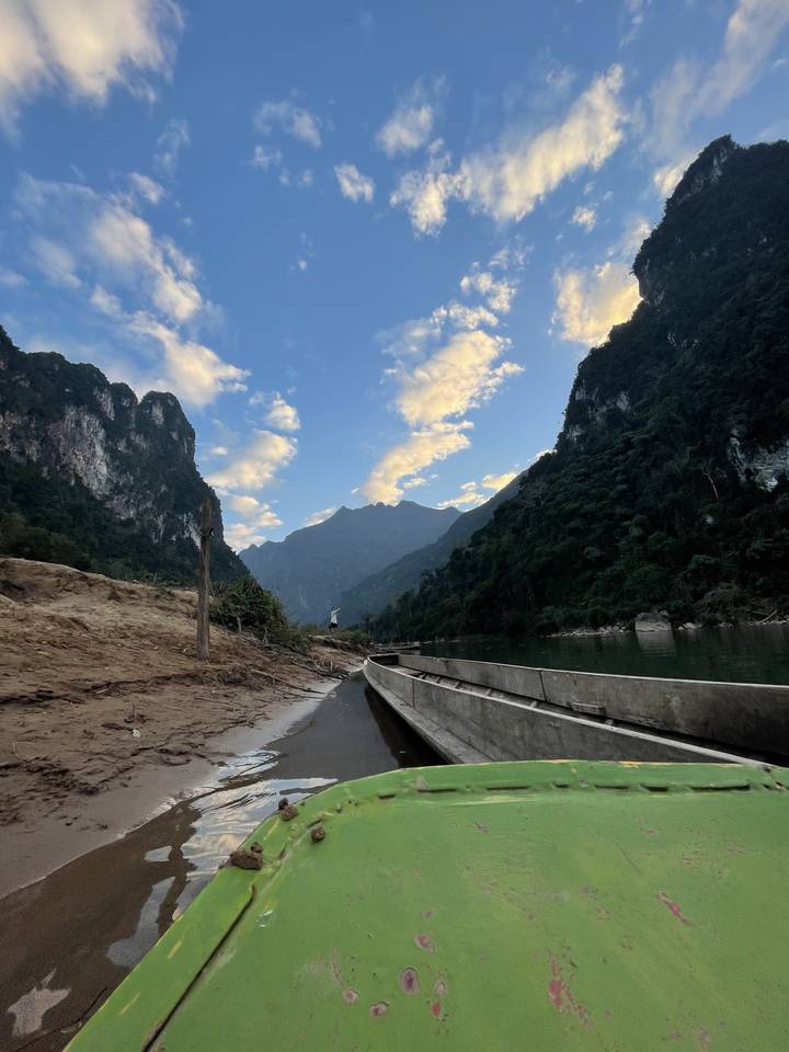 Boat on a river with rocky hills in the background.