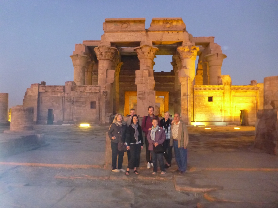 Groupe de personnes devant un temple égyptien au crépuscule.