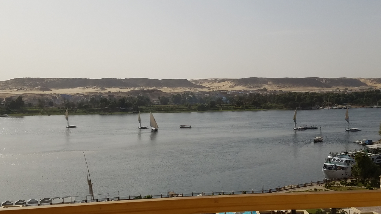 Bateaux naviguant sur une rivière aux rives sablonneuses.