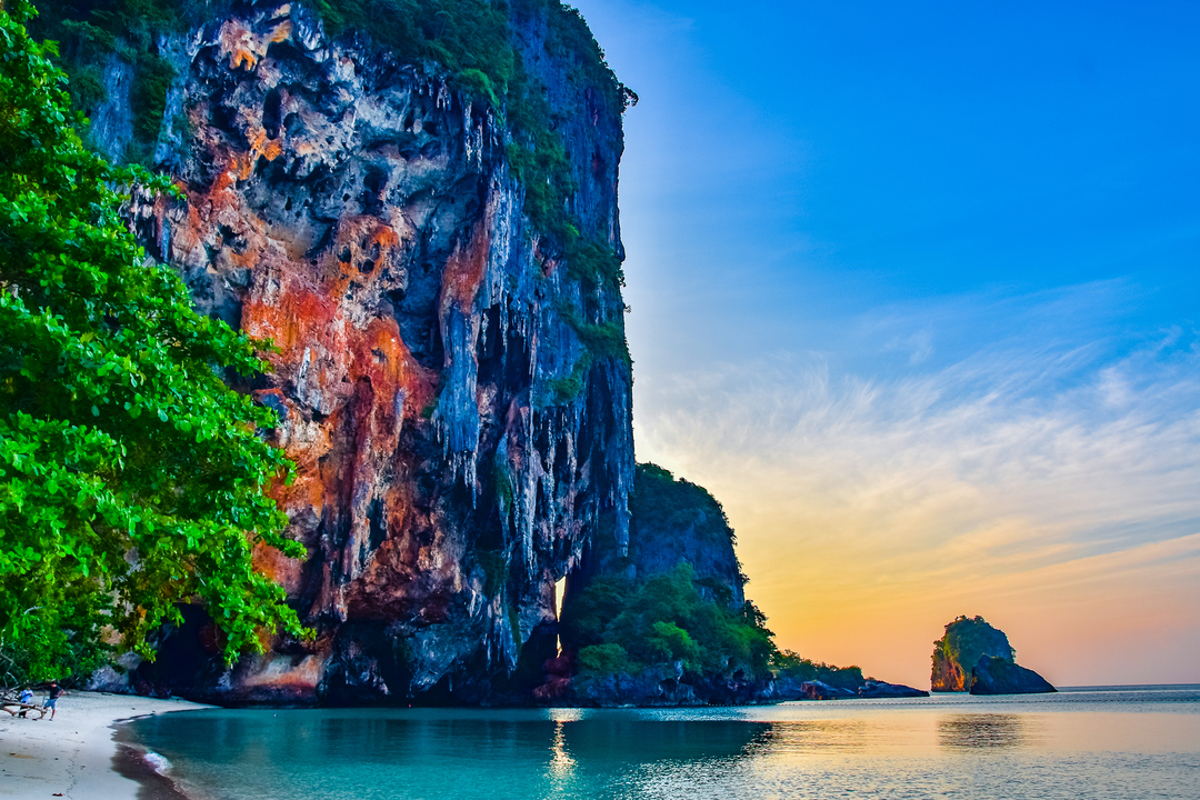 Cliffs at sunset with a tree and a small rock island.