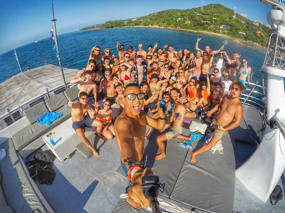 Large group of people celebrating on a boat deck.