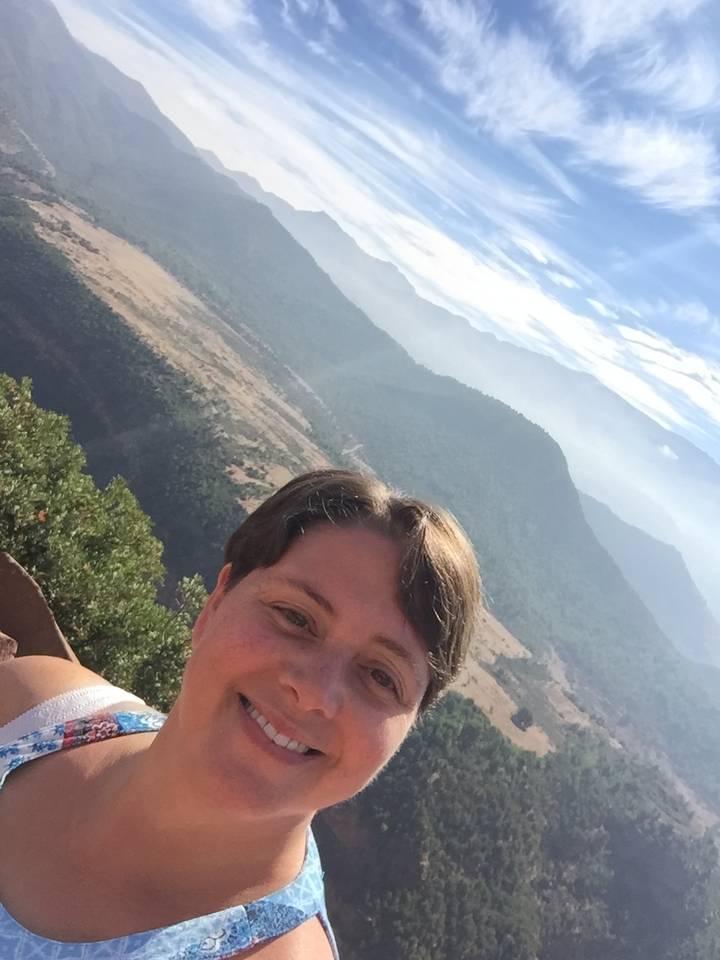 Personne prenant un selfie avec une vue panoramique sur la montagne.