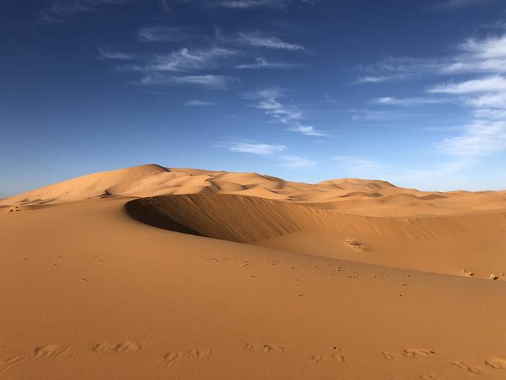 Golden sand dunes under a blue sky.