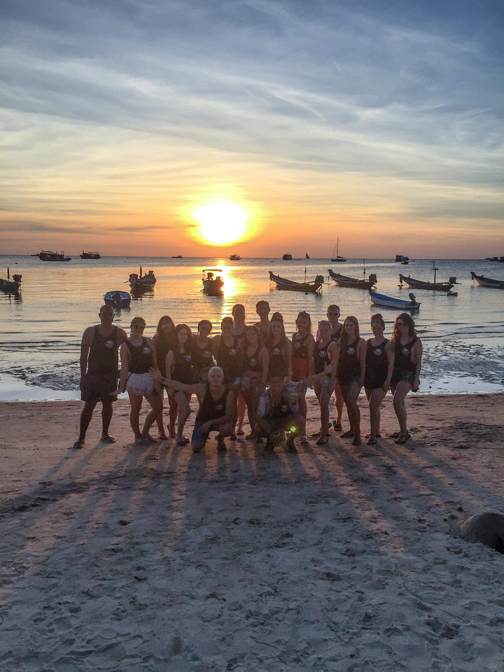 Group of people enjoying the beach during sunset.