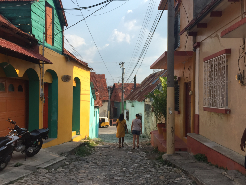 Deux personnes marchant dans une rue colorée.