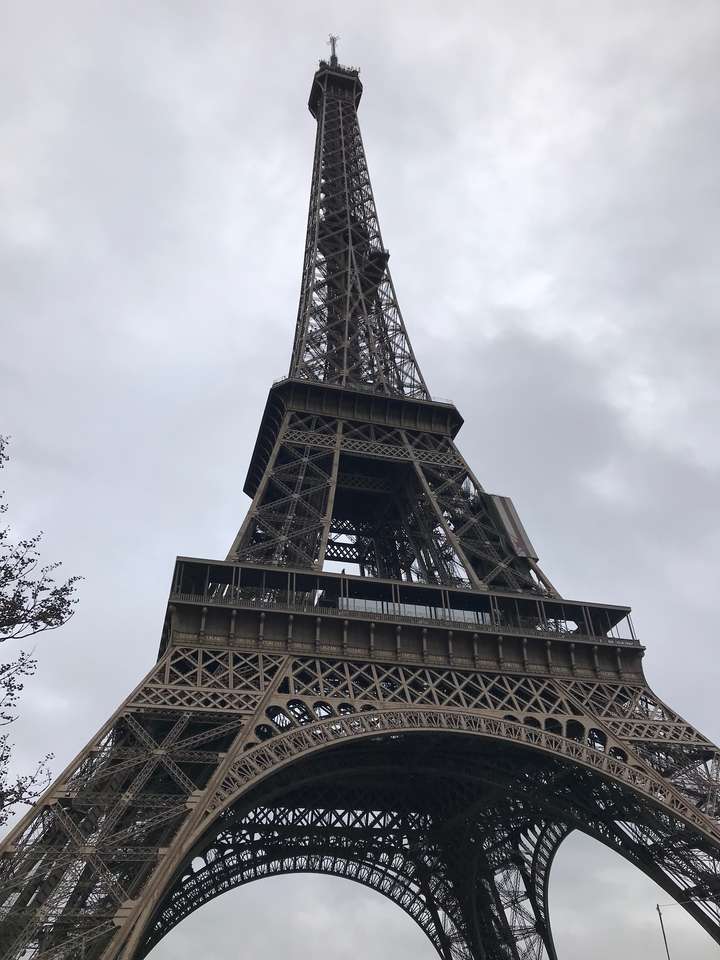 Tour Eiffel vue de dessous dans un ciel nuageux.