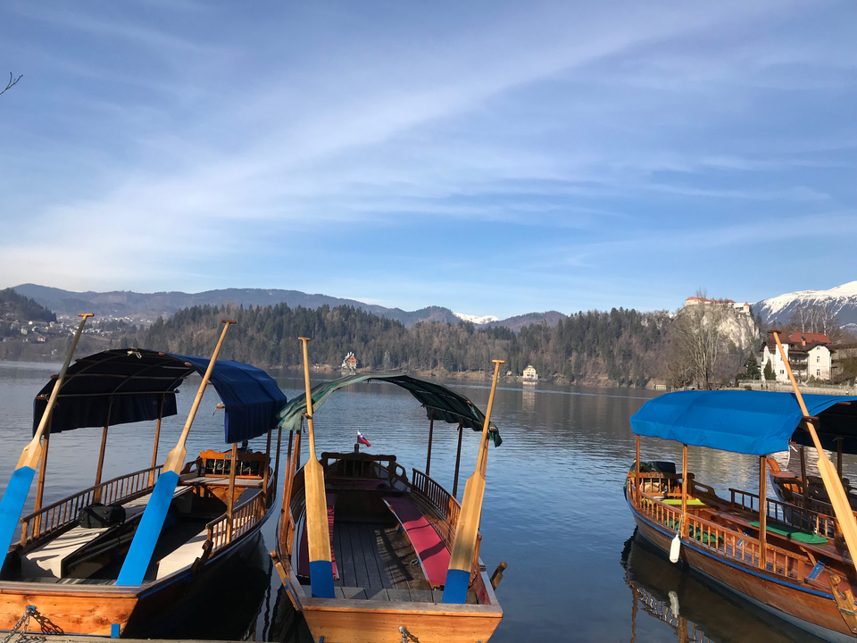 Bateaux à rames sur un lac avec des montagnes en arrière-plan.