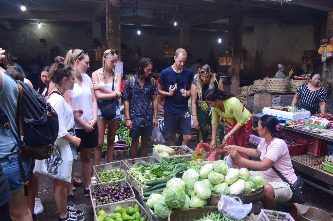 People shopping at a market with fresh vegetables.